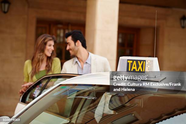 couple next to taxi - taxi españa stockfoto's en -beelden