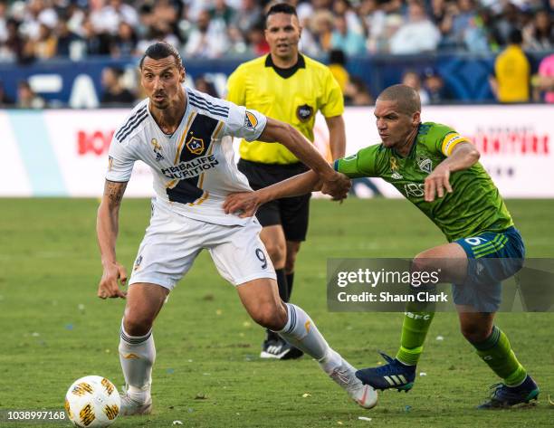 Zlatan Ibrahimovic of Los Angeles Galaxy battles Osvaldo Alonso of Seattle Sounders during the Los Angeles Galaxy's MLS match against Seattle...
