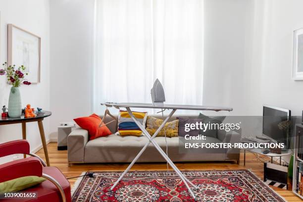 ironing board in cool apartment living room. - ferro da stiro foto e immagini stock