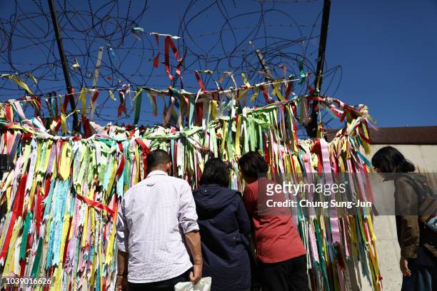 South Koreans hang ribbons wishing for reunification of the two Koreas on the wire fence at the Imjingak Pavilion, near the demilitarized zone...
