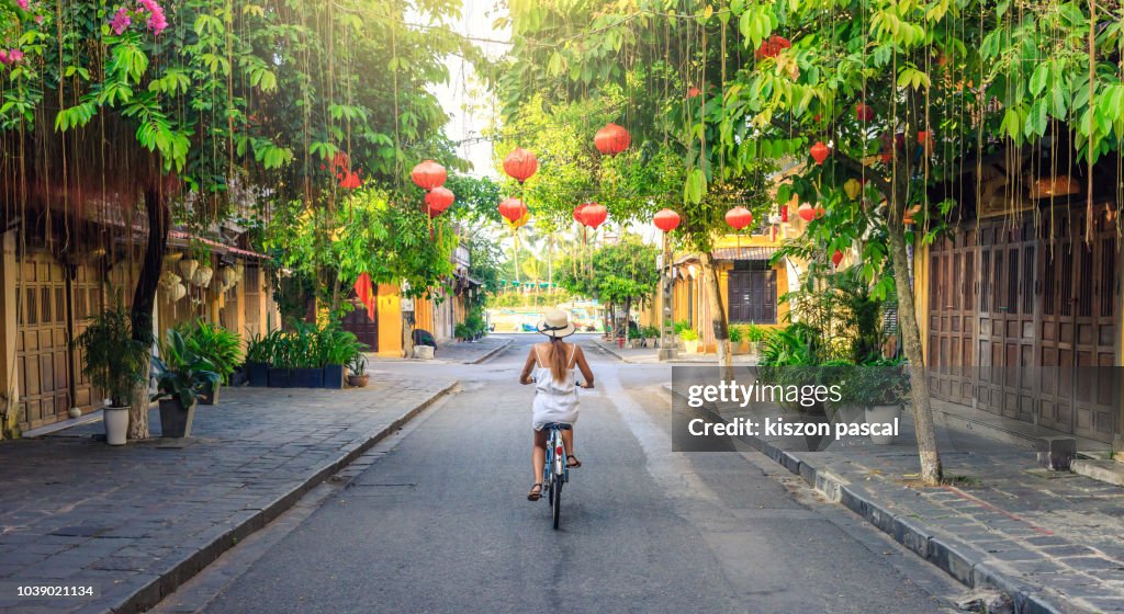 Women visiting the old city of Hoi An in Vietnam by bike during morning