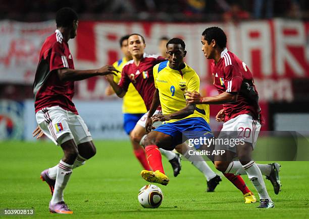 Ecuadorean footballer jaime Ayovi runs to elude Venezuelan footballers during a friendly match at the Metopolitano stadium in Barquisimeto, on...
