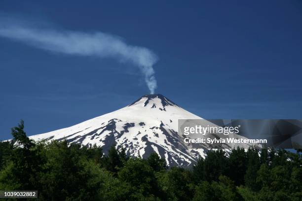 volcanic smoke rising from villarrica or rucapillan volcano, seen from pucon, chile - villarrica stock pictures, royalty-free photos & images