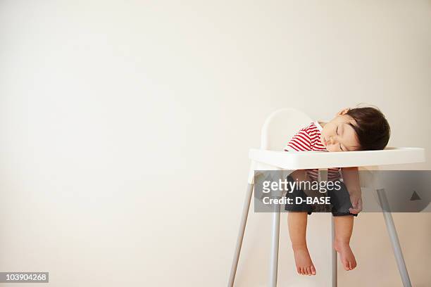 a baby boy sleeping in a high chair  - innocence stock pictures, royalty-free photos & images