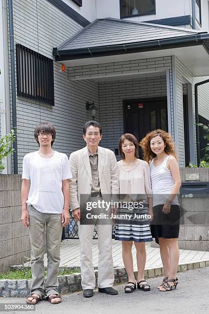 family portrait in front of house - family of four in front of house stock-fotos und bilder