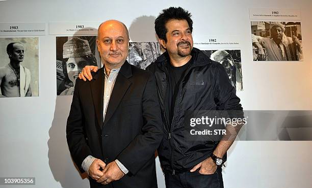 Bollywood film actors Anupam Kher and Anil Kapoor pose during the inauguration of artist Geeta Dass's exhibition of paintings based on Kher�s...