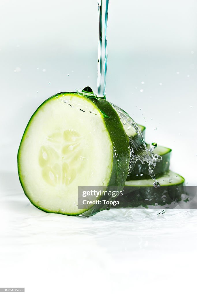 Water splashing over slices of cucumber