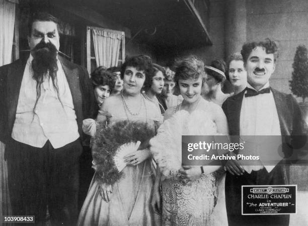 Eric Campbell , Marta Golden, Edna Purviance and Charlie Chaplin in a promotional still for 'The Adventurer', written and directed by Chaplin, 1917.