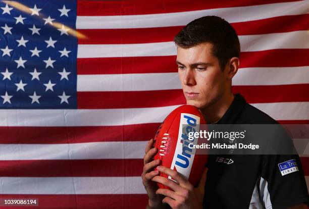 American Mason Cox of the Magpies poses in front of his national flag during a Collingwood Magpies AFL media opportunity at the Holden Centre on...