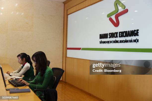 Employees work behind a counter at the Hanoi Stock Exchange in Hanoi, Vietnam, on Monday, Sept. 10, 2018. Vietnam has averaged economic growth of 6.3...