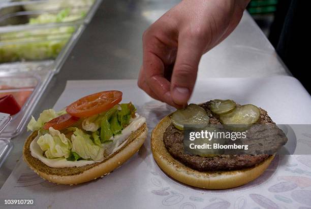 An employee places a pickle in a whopper burger at a Burger King restaurant in Basildon, U.K., on Wednesday, Sept. 8, 2010. Burger King Holdings Inc....