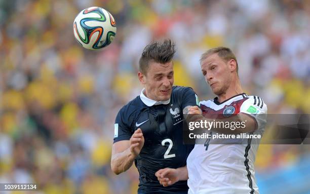 Mathieu Debuchy of France and Benedikt Hoewedes of Germany vie for the ball during the FIFA World Cup 2014 quarter final soccer match between France...