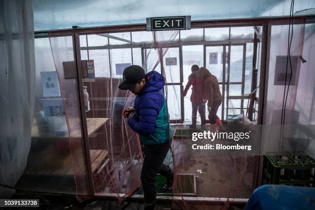 Workers enter a greenhouse at the Everyday Farm LLC Monnaran Solar Farm Project, a joint venture between Bridge LLC and Farmdo Co., in Ulaanbaatar,...