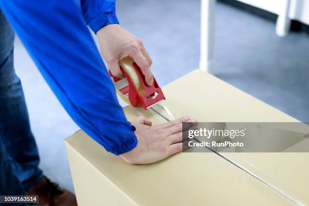 deliveryman packing box - packing parcel stockfoto's en -beelden