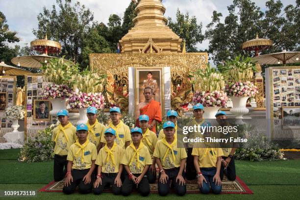 Twelve boys, members of the football team "Wild Boars", aged 11 to 17 and their 25-year-old coach, pose in front of a portrait of Thai king Maha...