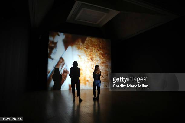 People watch a video piece by artist Luke Willis Thompson during the Turner Prize 2018 Photocall held at Tate Britian on September 24, 2018 in...