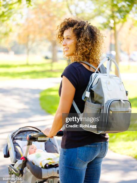 young mother in the park - diaper bag stock pictures, royalty-free photos & images