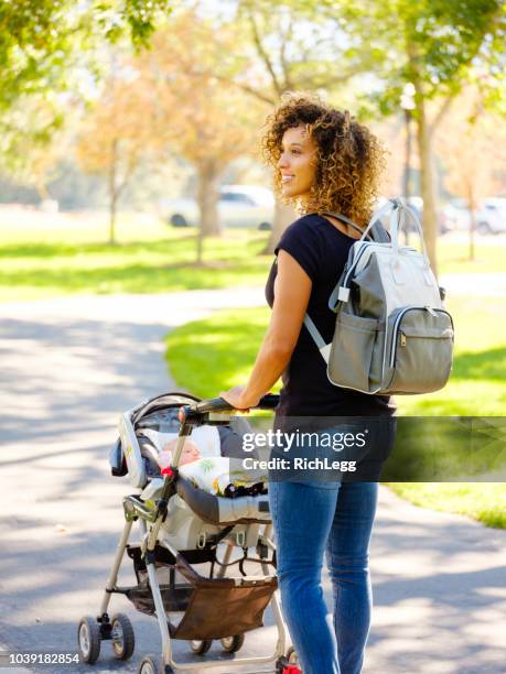 young mother in the park - diaper bag stock pictures, royalty-free photos & images