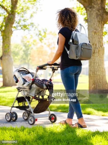 young mother in the park - diaper bag stock pictures, royalty-free photos & images