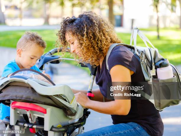 young mother in the park - diaper bag stock pictures, royalty-free photos & images