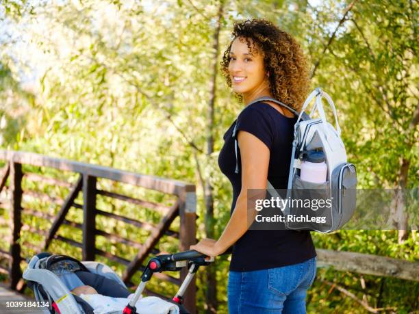 young mother in the park - diaper bag stock pictures, royalty-free photos & images