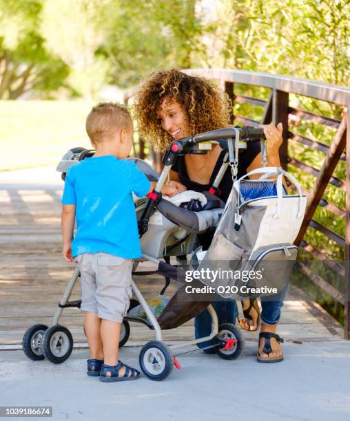 young mother in the park - diaper bag stock pictures, royalty-free photos & images