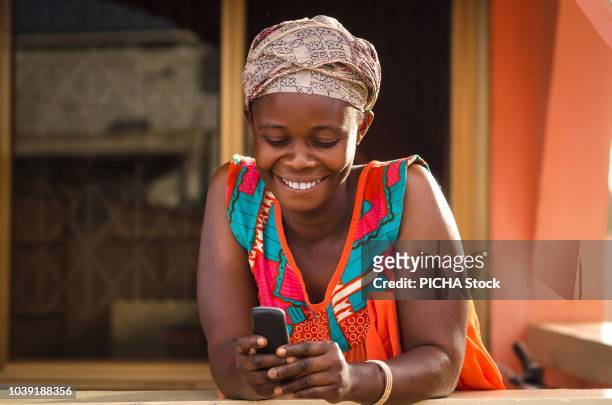 woman holding her mobile phone - ghana woman stock pictures, royalty-free photos & images