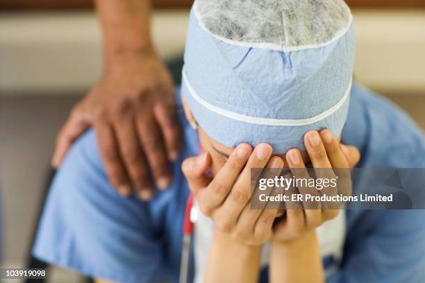 asian surgeon sitting with head in hands - sad nurse stock pictures, royalty-free photos & images