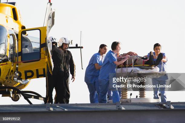 Medical personnel rushing patient from helicopter