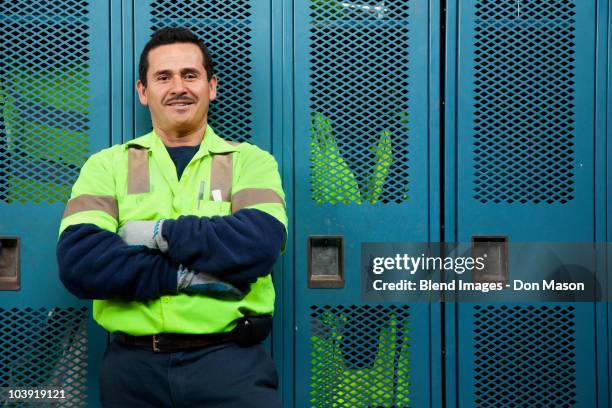 hispanic sanitation worker in locker room - vuilnisman stockfoto's en -beelden