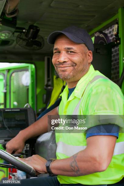 african american man driving garbage truck - garbage truck driving stock pictures, royalty-free photos & images