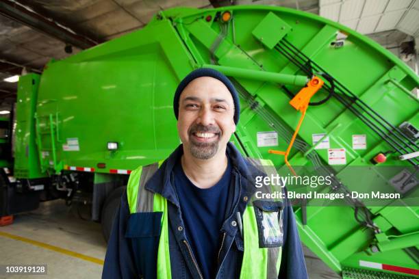 pacific islander man standing by garbage truck - garbage truck stock pictures, royalty-free photos & images