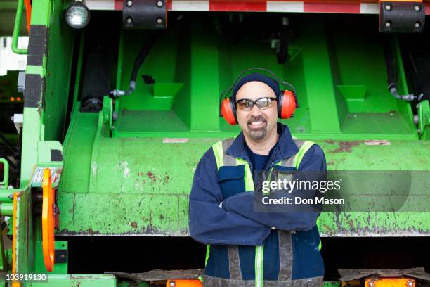 pacific islander man standing by garbage truck - vuilnisman stockfoto's en -beelden