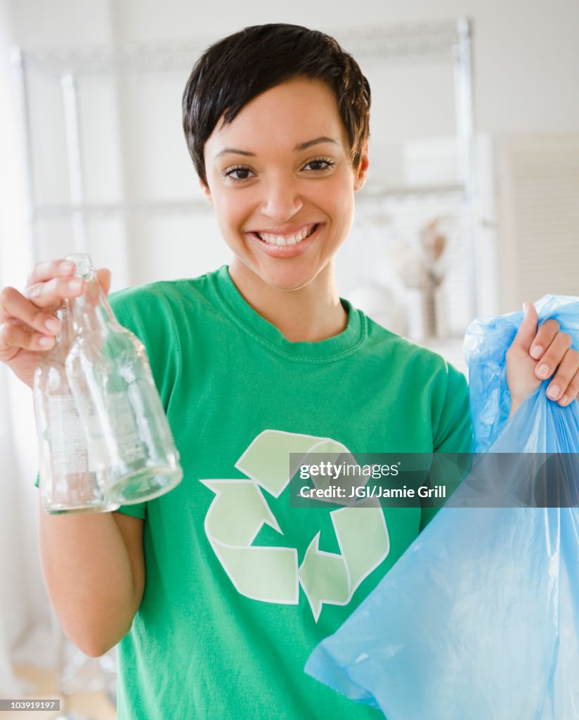 Mixed race woman recycling bottles