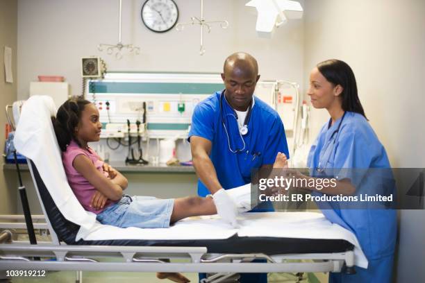 doctors treating girl's leg with bandages - applying plaster stock pictures, royalty-free photos & images