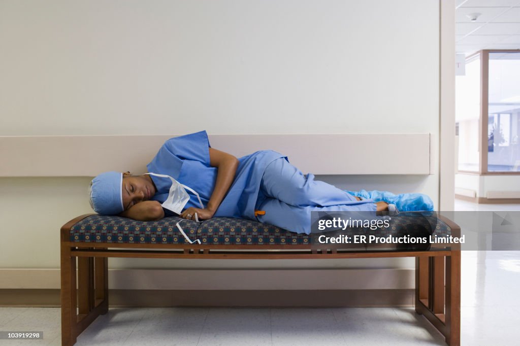Black surgeon napping on hospital bench