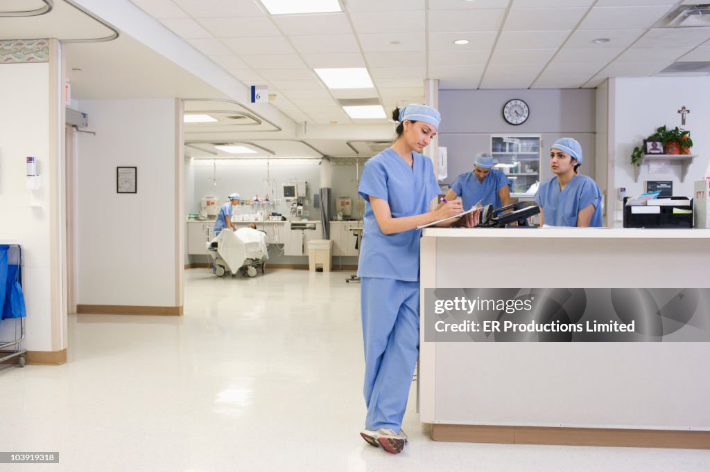 Asian surgeon writing on medical chart