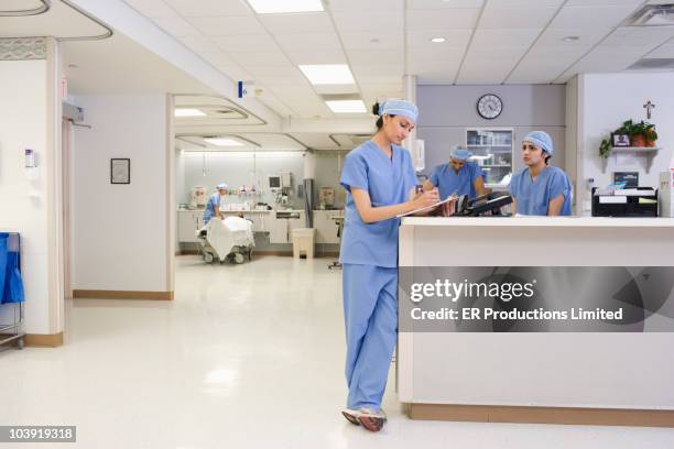 asian surgeon writing on medical chart - nurse station stock pictures, royalty-free photos & images