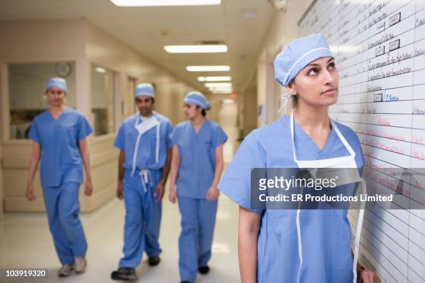 asian surgeons looking at hospital schedule - nurse thinking stock pictures, royalty-free photos & images