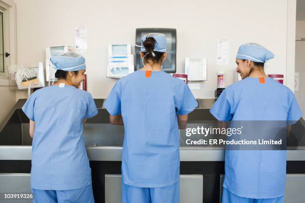 asian surgeons sterilizing hands preparing for operation - nursing scrubs stock pictures, royalty-free photos & images