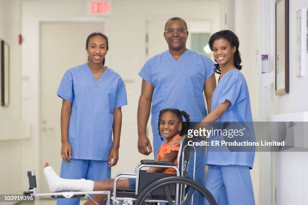 doctors standing with girl with broken leg - african cast broken leg stockfoto's en -beelden