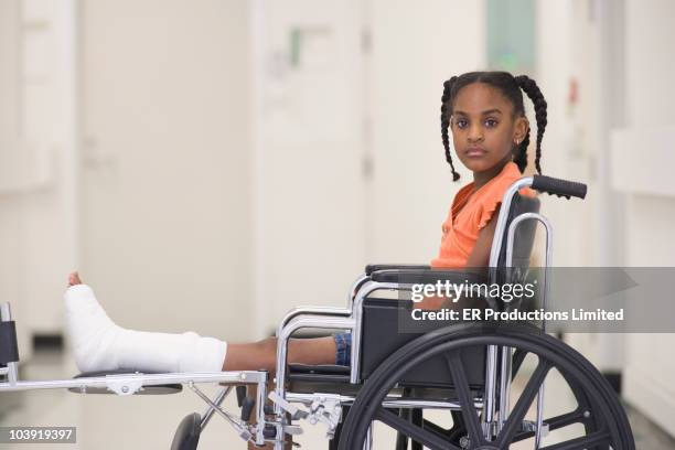 african american girl with broken leg sitting in wheelchair - african cast broken leg stockfoto's en -beelden