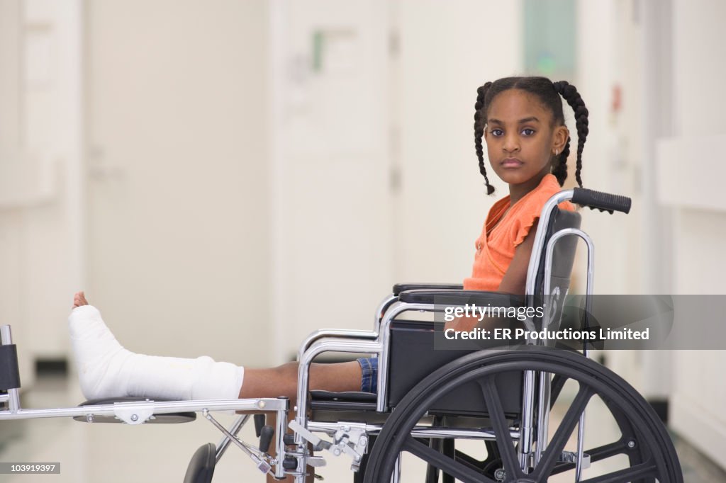 African American girl with broken leg sitting in wheelchair