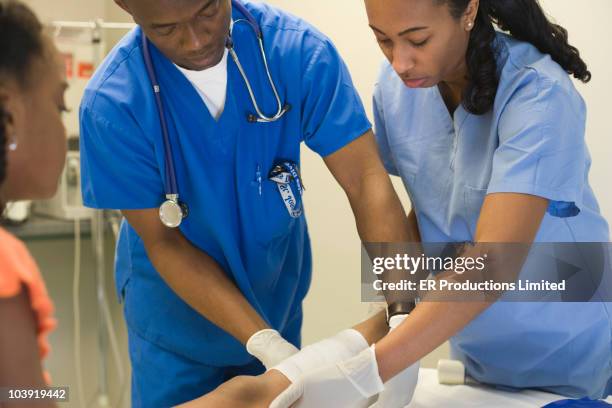 doctors treating girl's leg with bandages - applying plaster stock pictures, royalty-free photos & images