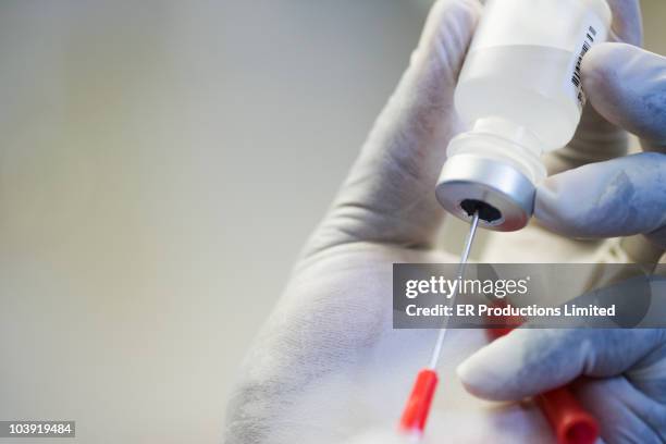 close up of hand in rubber glove filling syringe - preparing drug in hospital nurse stock pictures, royalty-free photos & images