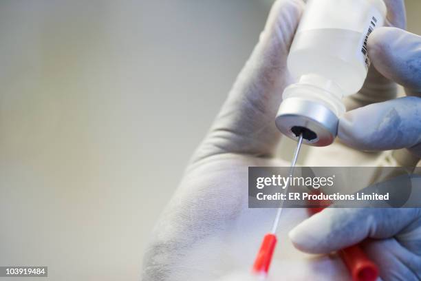 close up of hand in rubber glove filling syringe - medicinflaska bildbanksfoton och bilder
