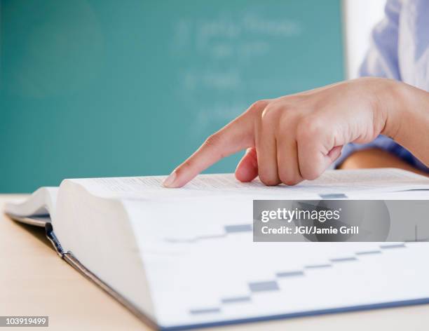 finger pointing to word in dictionary - woordenboek stockfoto's en -beelden