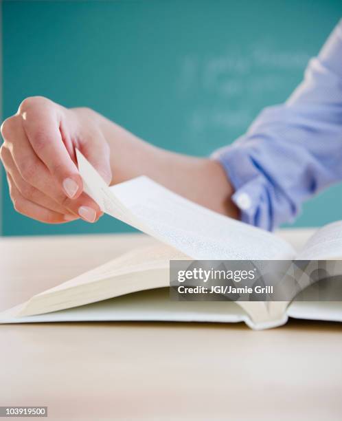 hand turning page in book - hand turning page stock pictures, royalty-free photos & images