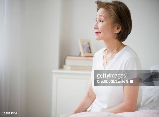 japanese woman sitting on bed - japanese old woman stockfoto's en -beelden