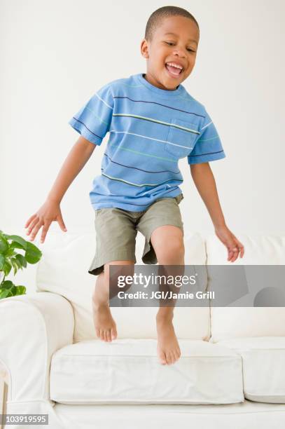 african american boy jumping off sofa - children only 個照片及圖片檔